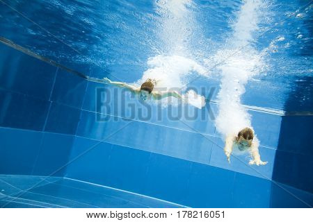 a young couple is jumping into the water from a diving plattform