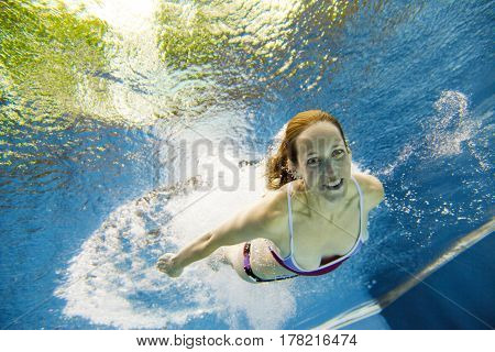 a young woman is jumping into the water from a diving plattform