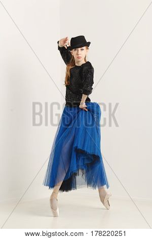 Sweet hipster ballerina in a tutu pointe shoes and glasses dancing with hat. Modern dance. Youth culture