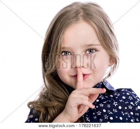 Little girl requires silence. Young beautiful kid has put forefinger to lips as sign of silence, isolated on white background