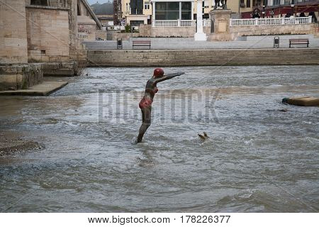 SKOPJE, MACEDONIA - March 20, 2017: Bronze statue of girl swimmer jumping in Vardar river at Skopje. Bronze statue of girl swimmer at Vardar river in Skopje, Macedonia.