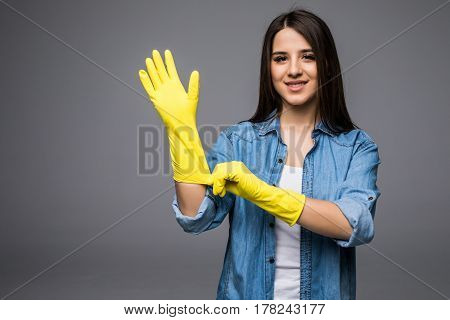 Cleaning lady getting spring cleaning ready putting on rubber gloves. Cleaning woman smiling happy at camera