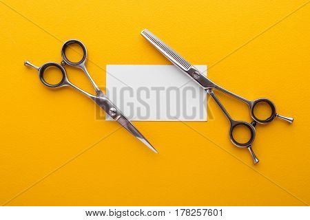 Professional Hairdresser's Scisors With Business Card On Yellow Background