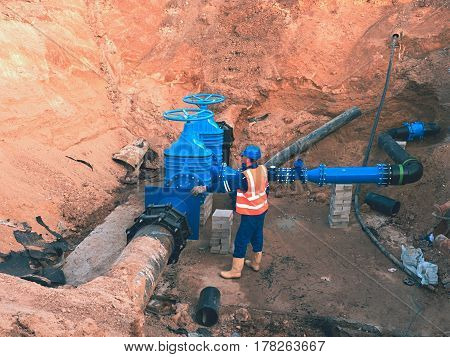 Main City Water Supply Pipeline. Technical Staff In Reflective Vest Underground