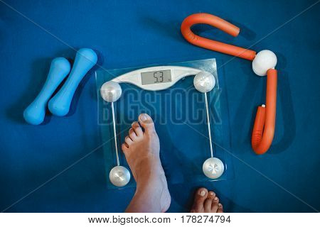 Weight scale healthy snack measuring tape and dumbbells on a table weight loss and sports concept flat lay