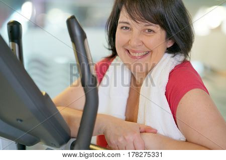 Overweight woman at the gym doing cardio exercises on bike