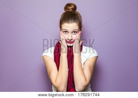 Unhappy mistake concept. portrait of a young cute woman with red scarf and freckles on her face unhappy emotional expression concept on purple background.