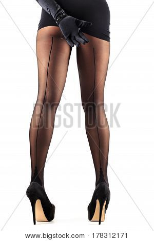Sexy female legs in beautiful stylish stockings and high heels shoes black gloves and dress isolated on white background