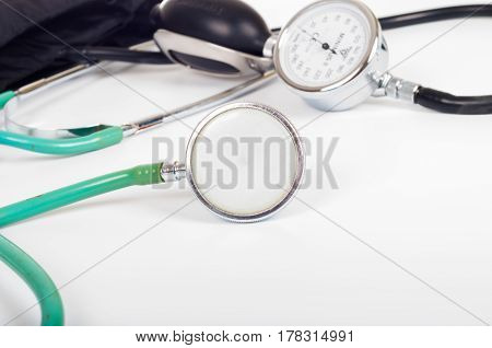 Health care concept - blood preasure cuff monitor and stethoscope on white background