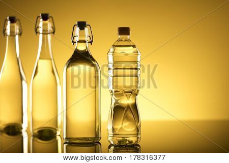 Vegetable oil made from rapeseed in bottles on glass table