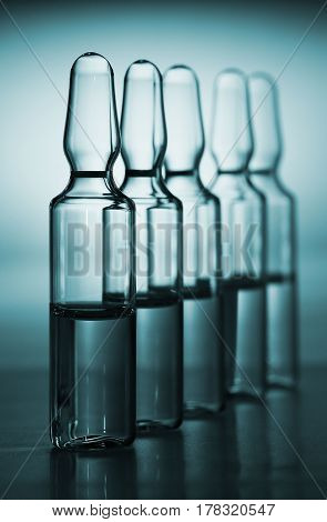 Row of ampulas with medicine on blue background