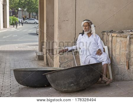 Nizwa Oma 24th March 2017: old Omani man selling old copper cooking dishes at the market
