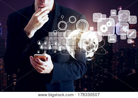 Male hands using smartphone with digital business charts icons and globe. Blurry night city background. Techn concept. 3D Rendering