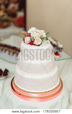 white wedding cake with roses on top