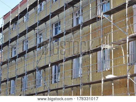 Energy efficiency office wall renovation for energy saving. Exterior house wall heat insulation with mineral wool building hospital under construction.