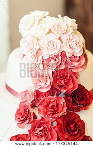 white red pink wedding cake with eatable roses on a side