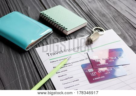 Travel preparation concept with insurance application form and credit cards for online payment on wooden table background