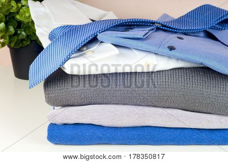 stack of clothing isolated on white sweaters Shirts knitwear space for text