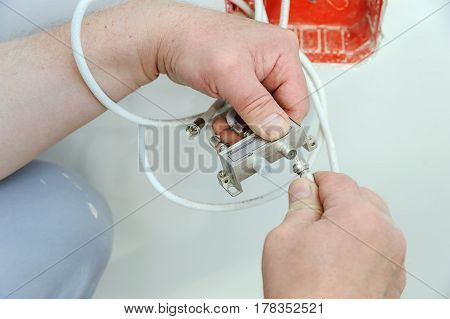 Man's hands inserts a TV antenna cable to a splitter.