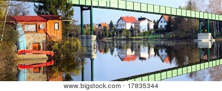 Houses on the bank and iron bridge over a Czech Valley Reservoir - Radbuza River- Pilsen City - Czech Republic Europe
