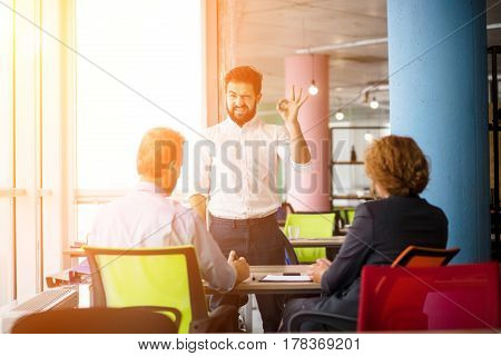 Toned of young bearded man knows how to get positive assessment to get job position. Confident handsome man communicating with employees.