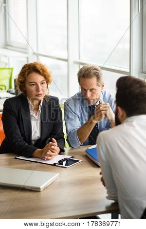 Deal concept. Company partnership concept. Business man and woman looking at man sitting in front. Business people having negotiations with new business partner.