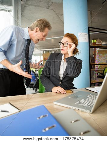 Angry boss man screaming and shouting at his worker, because he is not satisfied by her work. Mobbing, stress, work, scandal concepts.
