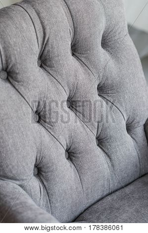 Seamless background texture close up of a grey sofa back with button detail on a thick cloth