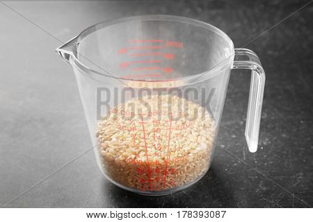 Brown rice in measure glass on kitchen table