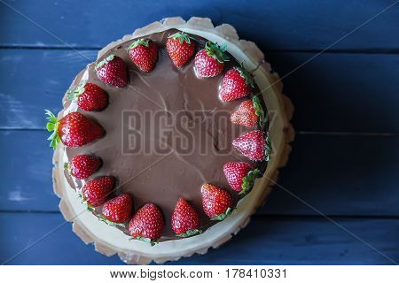Delicious cake with fresh strawberry and dark chocolate sauce, top view