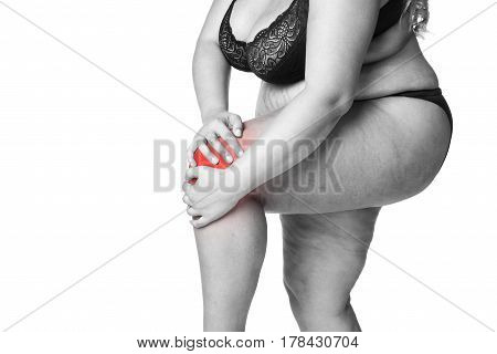 Knee pain fat woman with joint arthritis overweight female body isolated on white background black and white photo with red spots