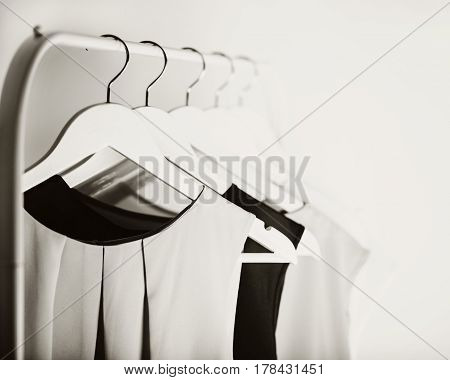 Black-and-white photo with the blur. Women's clothing on a white hanger. Selective focus.