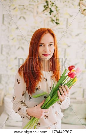red-haired girl holding a bouquet of tulips