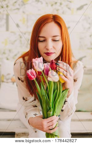 red-haired girl holding a bouquet of tulips