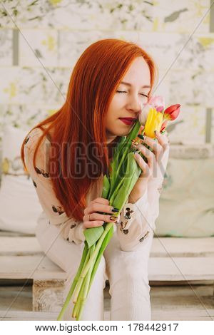 red-haired girl hollding a bouquet of tulips