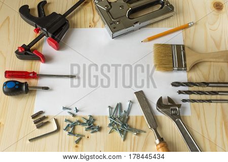 Tools for repairs in the house on a wooden table. Screws screwdrivers clamps