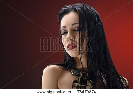 One in a million. Studio portrait of a gorgeous young brunette woman wearing smoky eyes makeup and red lipstick posing seductively with her eyes closed on red background copyspace beauty fashion style