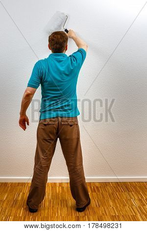 Man Paints Wall In White, Vertical Format
