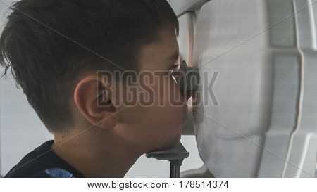 Close up view of boy checks eye vision in ophthalmology clinic, close up