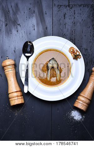 Cream Soup Brown Color With Fish, Pepperbox, Saltcellar And Spoon