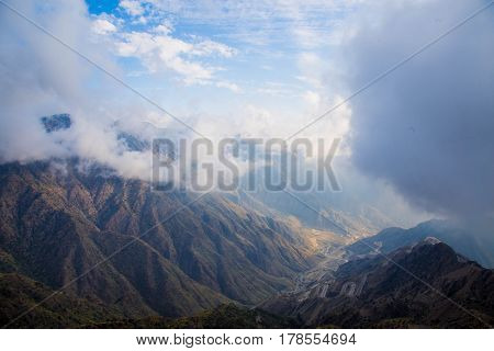 The Sun behind the clouds over mountains