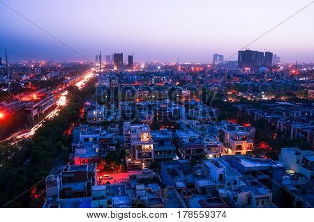 Noida cityscape at night with lights on the buildings and the construction cranes clearly visible