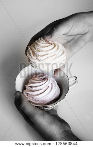 Marshmallow (zephyr) in woman's hands. zephyr in hands