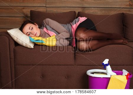 Woman in cleaning uniform asleep on a couch