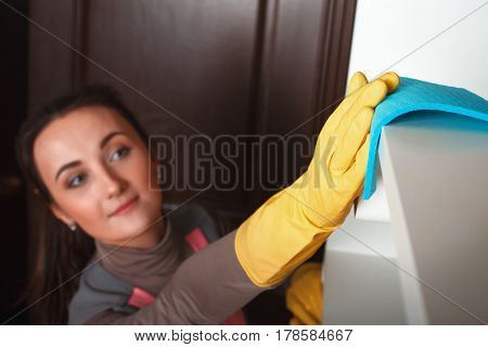Female hands in gloves cleans the shelf with spray