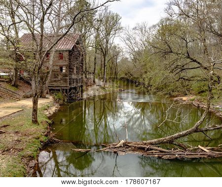 Childersburg Alabama USA - March 25 2017: Kymulga Grist Mill on the banks of Talledega Creek as viewed from the Kymulga Covered Bridge. This structure is orginal to the Civil War period.