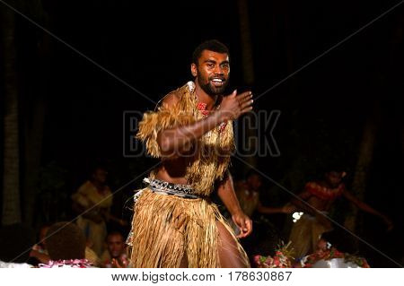 Indigenous Fijian men dancing a traditional male dance meke wesi the spear dance. Real people copy space