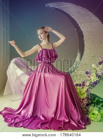 Cute girl dancer in a beautiful dress posing in the studio. Tinted photos.