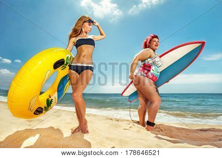 Beautiful young fat woman is runing to the summer sea with the surfboard