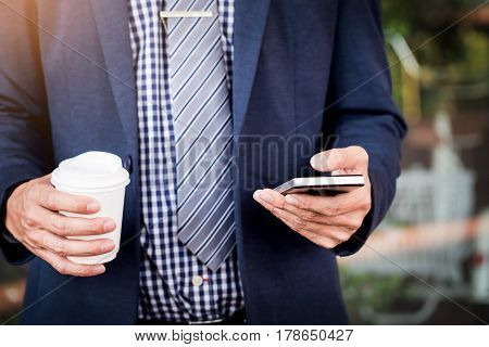 Successful Young Asian Man In Business Casual Attire In Relaxing Outdoor With Cup Of Coffee Looking